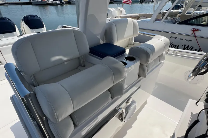 Slide: The Image of 2017 Belzona 325 Center Console boat with plush seating and cup holders, docked at marina. - 51