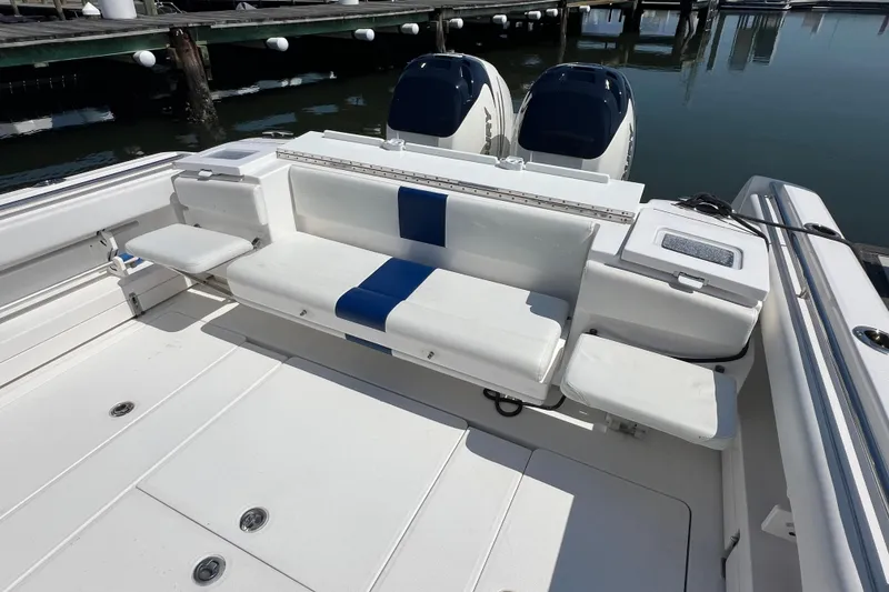 Slide: The Image of 2017 Belzona 325 Center Console boat with white seating and dual engines at dock. - 60
