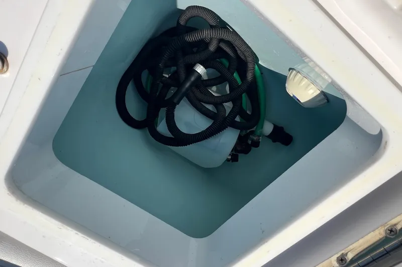 Slide: The Image of Storage compartment of 2017 Belzona 325 Center Console with coiled hoses. - 64