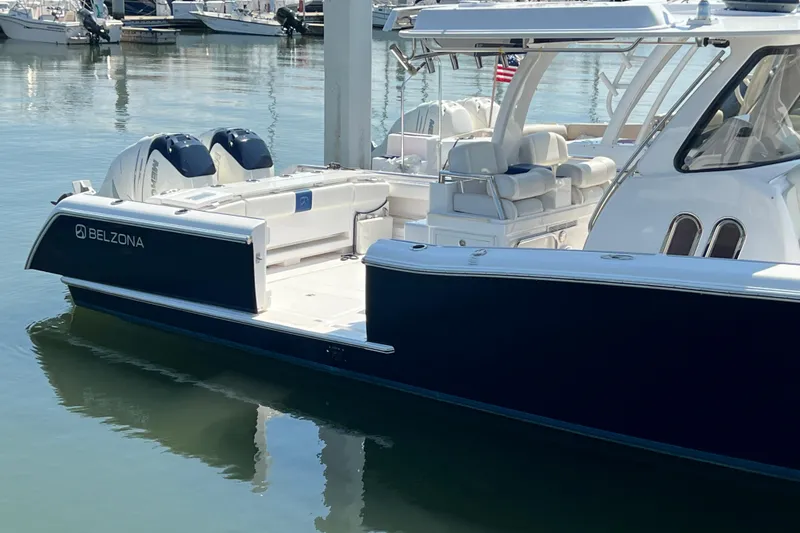 Slide: The Image of 2017 Belzona 325 Center Console boat docked in marina, featuring sleek design and dual engines. - 66