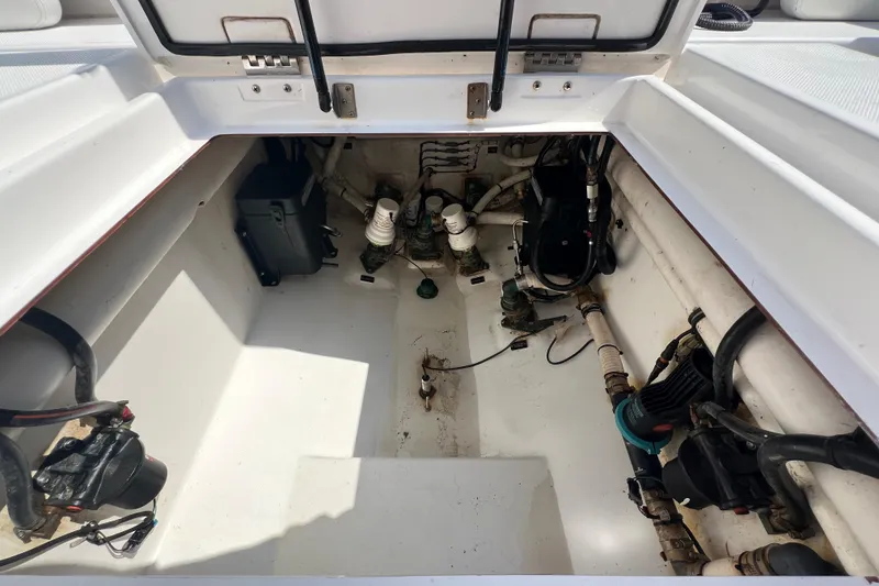 Slide: The Image of 2017 Belzona 325 Center Console boat storage compartment with visible equipment and wiring. - 75