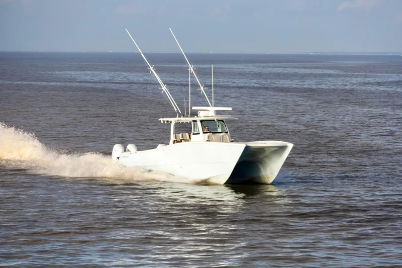 Slide: The Image of 2021 Freeman 47 boat cruising on open water with fishing rods. - 2