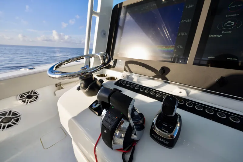 Slide: The Image of 2021 Freeman 47 boat helm with steering wheel and navigation controls, ocean view. - 21