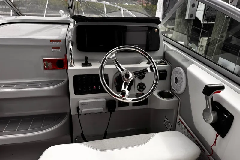 Slide: The Image of 2021 Regal 26 XO boat helm with steering wheel and control panel. - 10