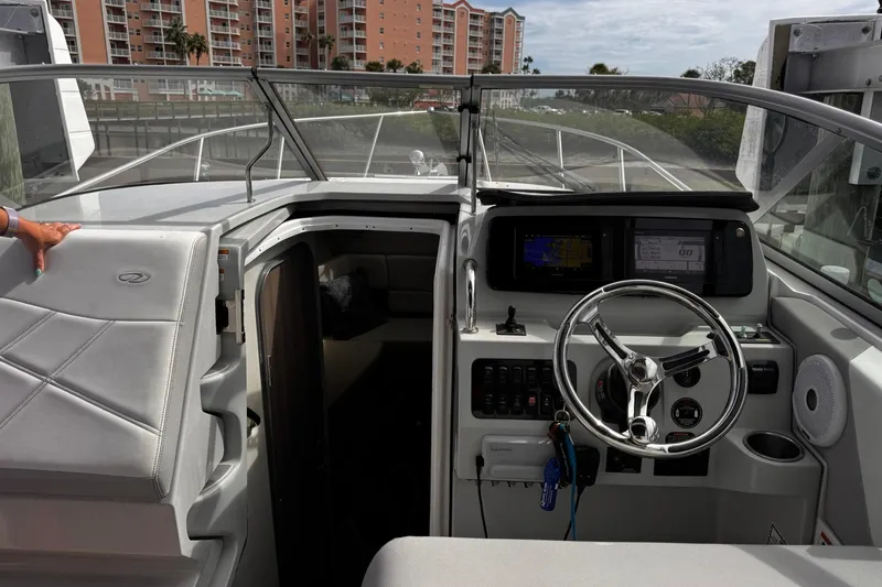 Slide: The Image of 2021 Regal 26 XO boat cockpit with steering wheel and navigation displays. - 14