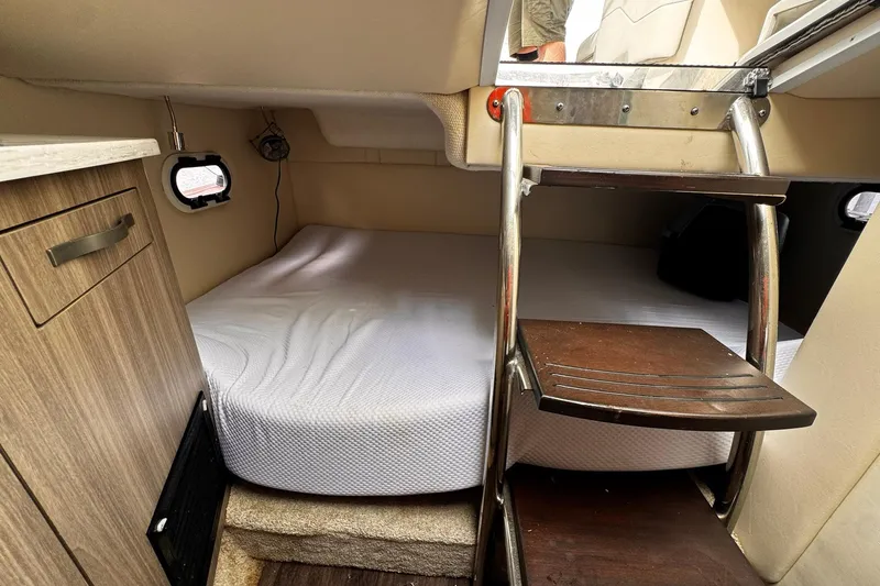Slide: The Image of 2021 Regal 26 XO cabin interior with bed, ladder, and storage. - 16