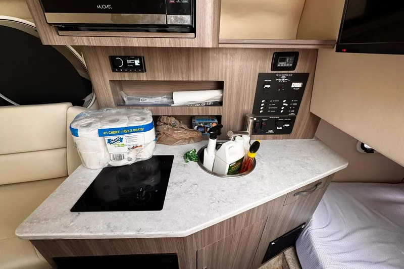 Slide: The Image of 2021 Regal 26 XO boat interior with kitchenette, control panel, and storage. - 17