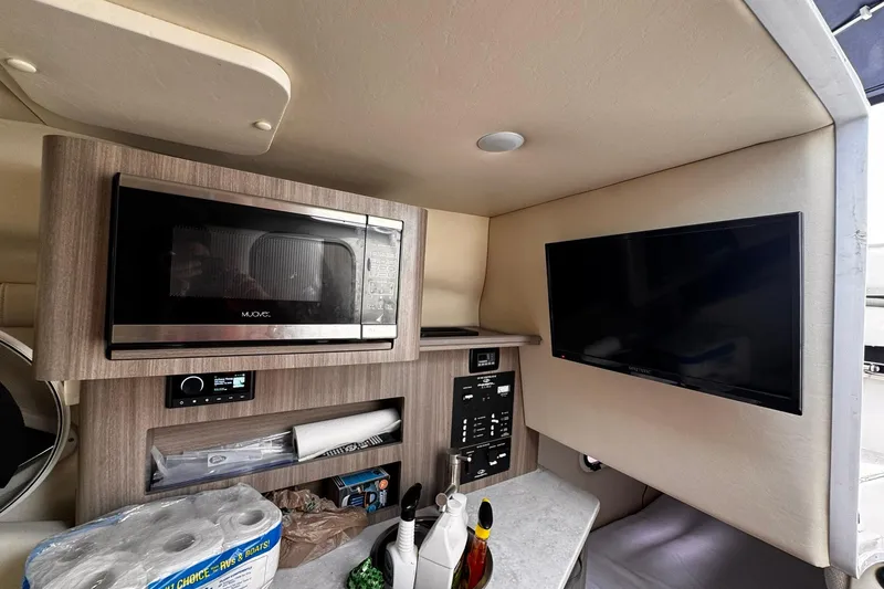Slide: The Image of 2021 Regal 26 XO boat interior with microwave, TV, and control panel. - 22