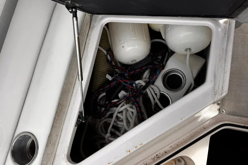 Slide: The Image of Open storage compartment on 2021 Regal 26 XO boat with ropes and fenders. - 28