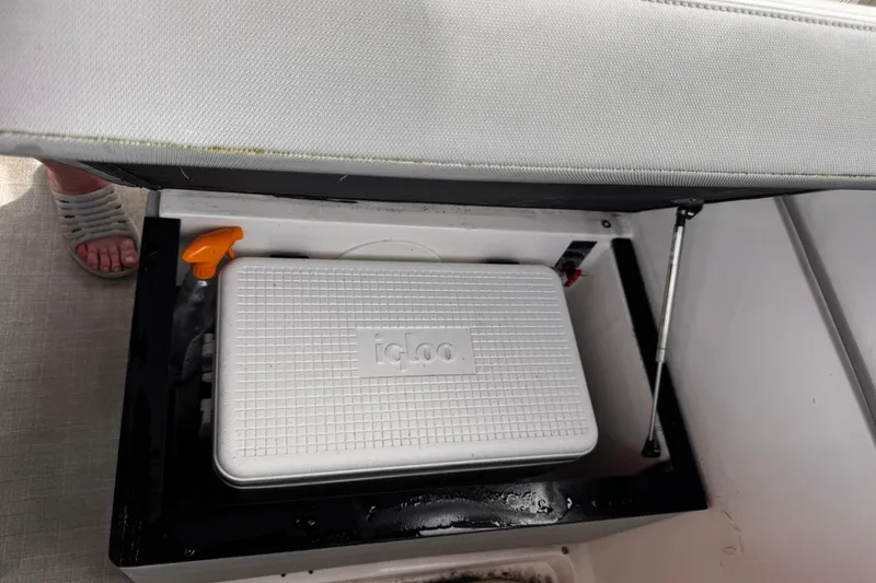 Slide: The Image of Storage compartment in a 2021 Regal 26 XO boat with an Igloo cooler. - 31