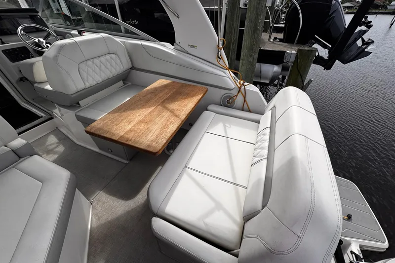 Slide: The Image of 2021 Regal 26 XO boat interior with white seating and wooden table. - 40