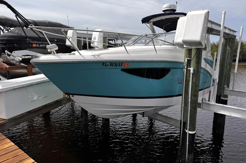 Slide: The Image of 2021 Regal 26 XO boat in blue, docked on a lift at a marina. - 5