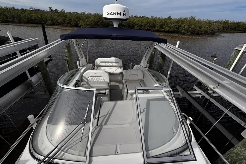 Slide: The Image of 2021 Regal 26 XO boat docked, featuring Garmin equipment and spacious seating. - 7