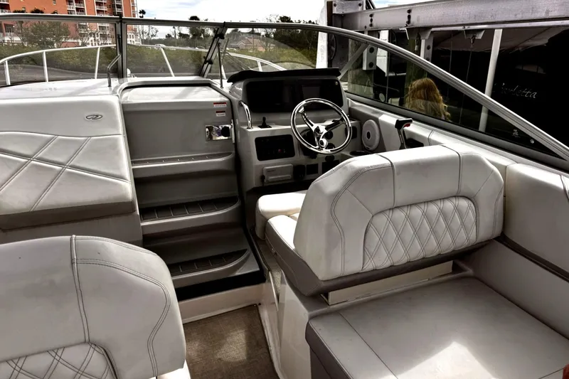 Slide: The Image of Interior of a 2021 Regal 26 XO boat with white seating and steering wheel. - 9