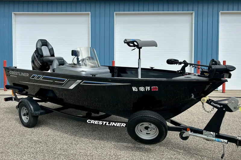 The Image of 2018 Crestliner CVN16 boat on trailer, black exterior, parked near blue building. - 1