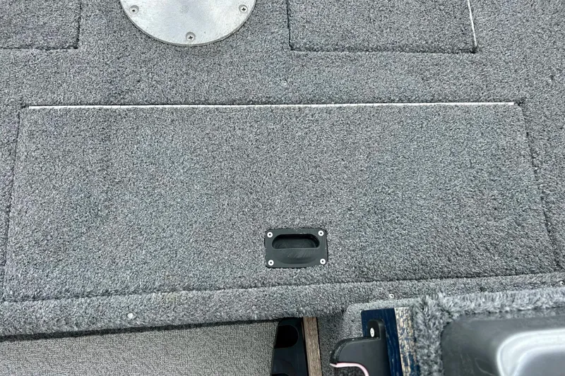 Slide: The Image of Carpeted deck of a 2018 Crestliner CVN16 boat with storage compartment. - 19