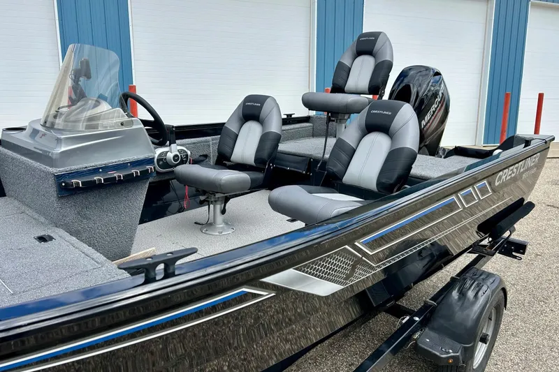 Slide: The Image of 2018 Crestliner CVN16 boat with modern seating and sleek design, parked outdoors. - 2