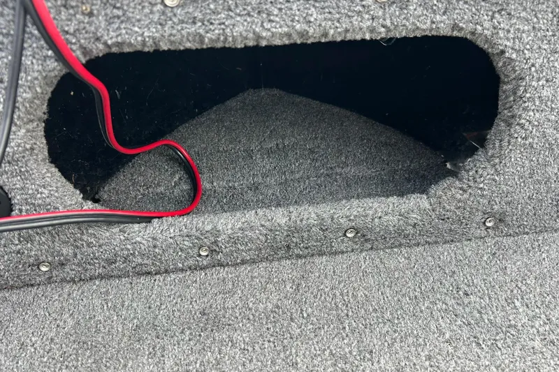 Slide: The Image of Carpeted storage compartment in a 2018 Crestliner CVN16 boat with visible wiring. - 40