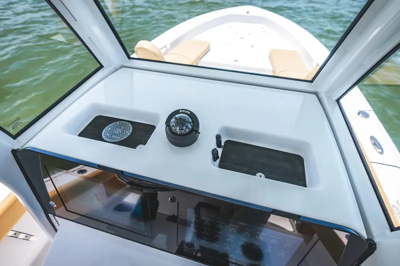 Slide: The Image of 2026 Sportsman Masters 267OE Bay Boat dashboard with compass and storage compartments. - 10