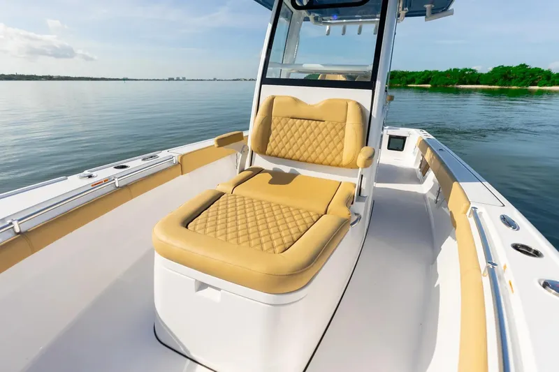 Slide: The Image of 2026 Sportsman Masters 267OE Bay Boat with tan seating, on calm water. - 5