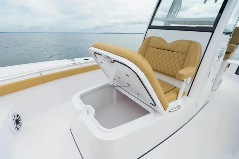 Slide: The Image of 2026 Sportsman Masters 267OE Bay Boat with open storage compartment and tan seating. - 6