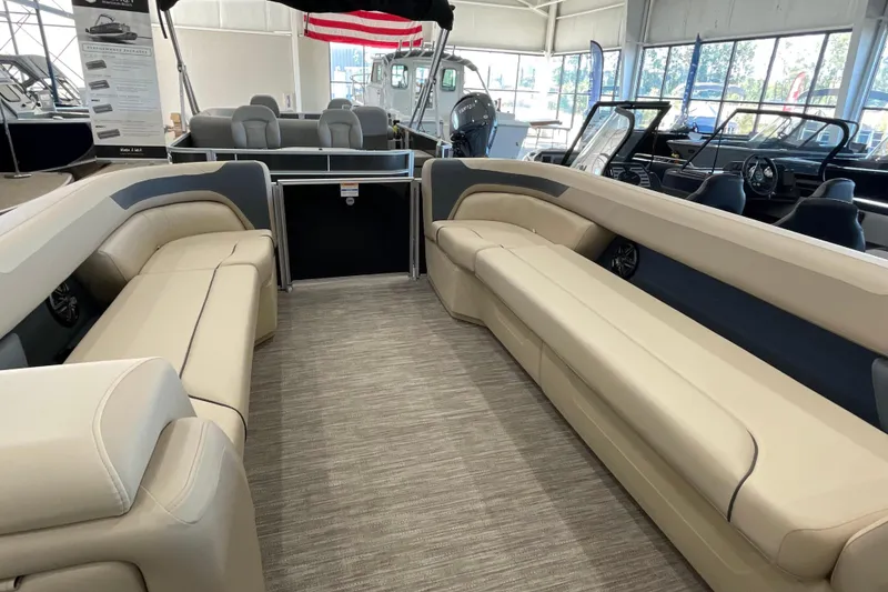 Slide: The Image of 2026 Godfrey Sweetwater 2286 C pontoon boat interior with beige seating in showroom. - 4