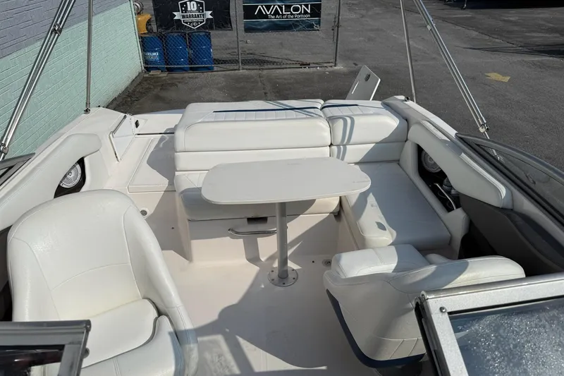Slide: The Image of 2006 Regal 2000 Bowrider interior with white seating and table, parked outdoors. - 5
