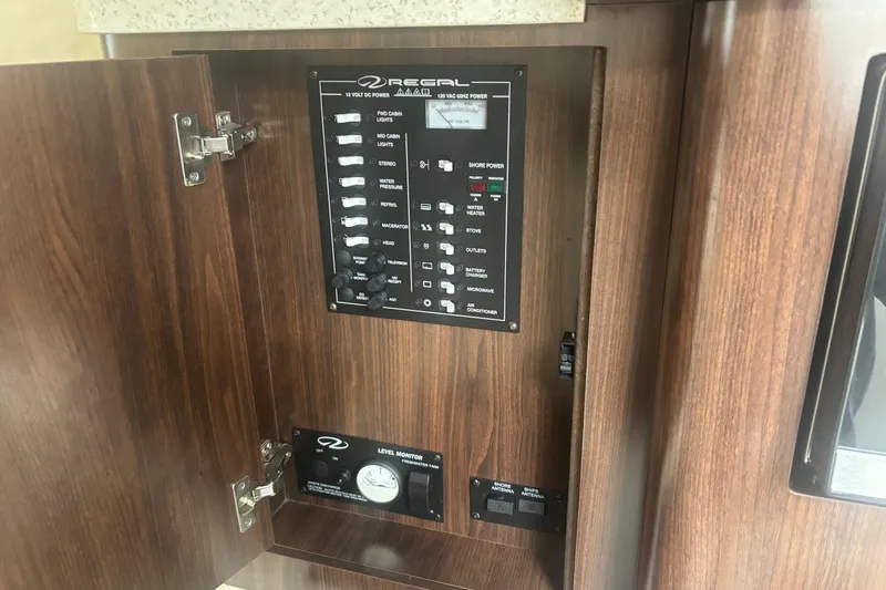 Slide: The Image of Control panel inside 2016 Regal 28 Express boat, featuring various switches and indicators. - 11