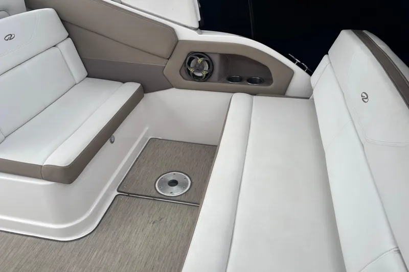 Slide: The Image of 2016 Regal 28 Express boat interior with white seating and cup holders. - 2