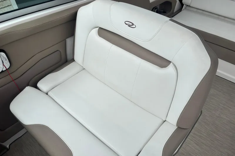 Slide: The Image of 2016 Regal 28 Express boat interior seating with white and beige upholstery. - 4