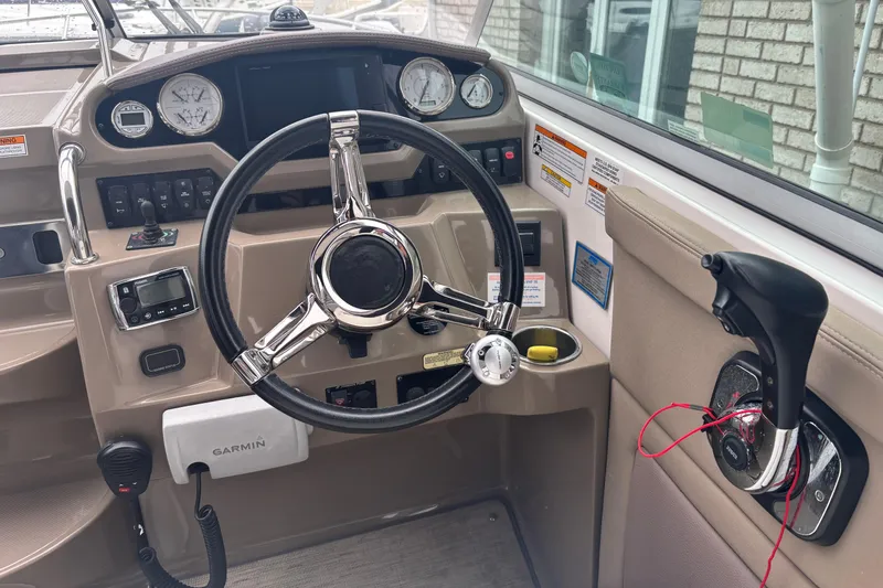 Slide: The Image of 2016 Regal 28 Express boat dashboard with steering wheel and navigation controls. - 5