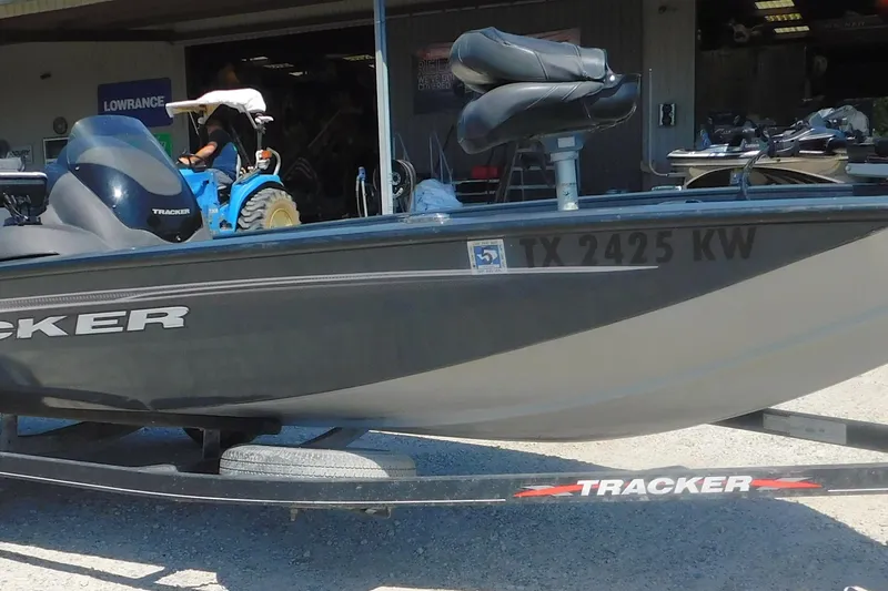 Slide: The Image of 2022 Tracker Pro Team 175 boat on trailer, parked outside a building. - 2