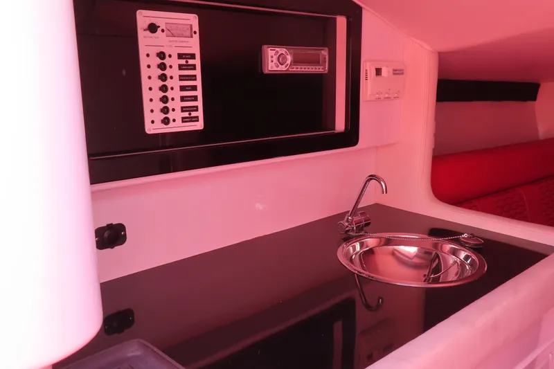Slide: The Image of 2009 Donzi 35ZR boat interior with sink, control panel, and red seating. - 16
