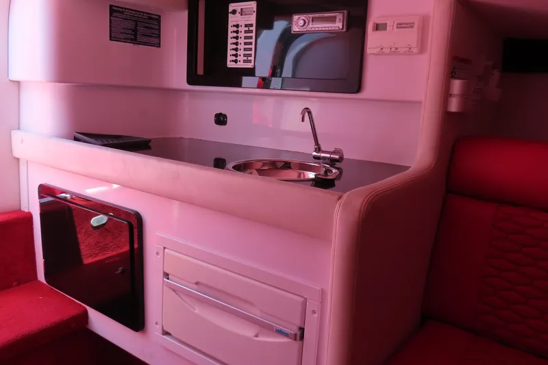 Slide: The Image of Interior of 2009 Donzi 35ZR boat featuring a compact kitchenette with sink and control panel. - 17