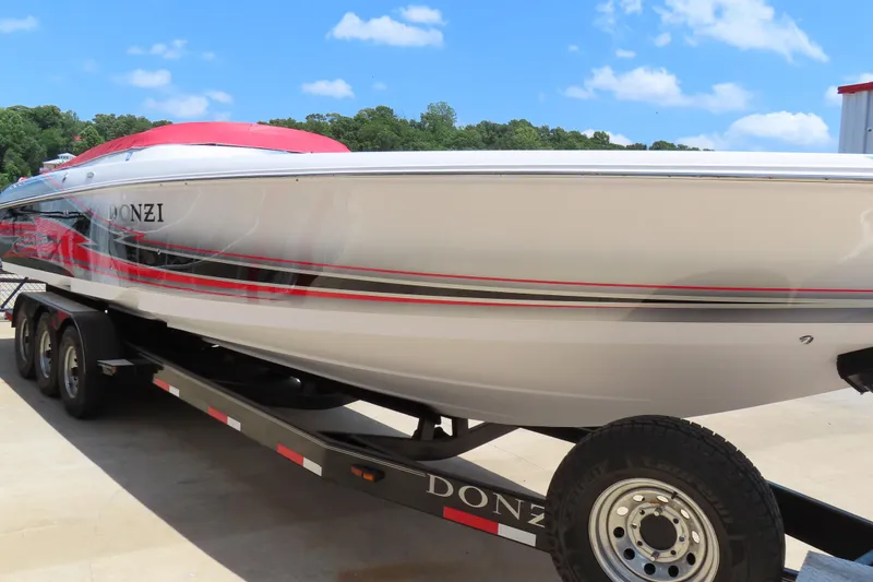 Slide: The Image of 2009 Donzi 35ZR speedboat on trailer, featuring sleek design and vibrant red accents. - 2
