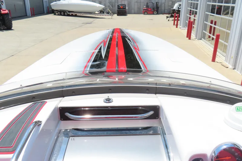 Slide: The Image of 2009 Donzi 35ZR speedboat with sleek red and black design, docked in a marina. - 8