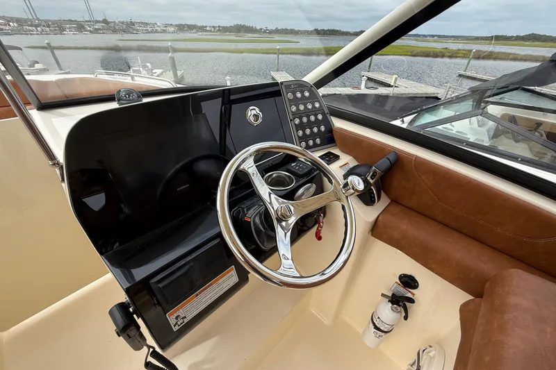 Slide: The Image of 2023 Scout 255 Dorado boat cockpit with steering wheel and control panel. - 25