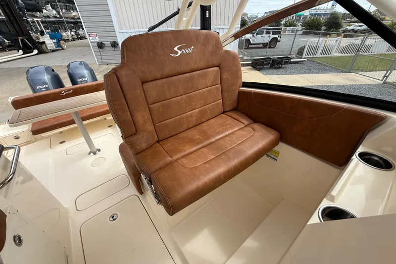 Slide: The Image of 2023 Scout 255 Dorado boat interior with brown leather seating and dual engines. - 27