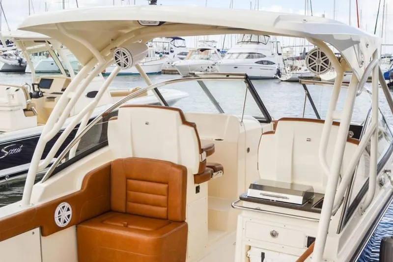 Slide: The Image of Manufacturer Provided Image: 2023 Scout 255 Dorado boat interior with brown leather seats, docked at marina. - 28