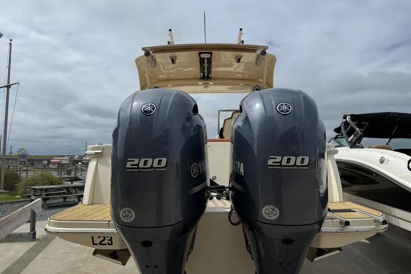 Slide: The Image of 2023 Scout 255 Dorado boat with dual Yamaha 200 engines, docked outdoors. - 3