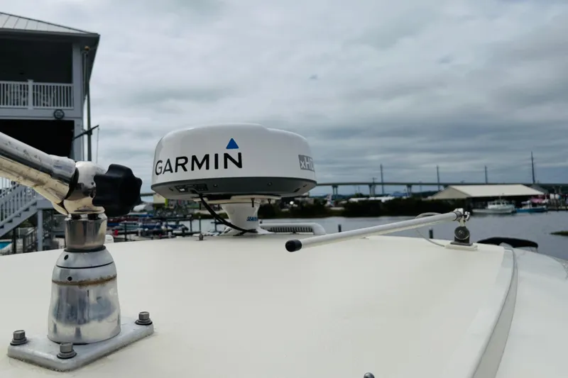 Slide: The Image of 2023 Scout 255 Dorado boat with Garmin radar, docked near a marina under cloudy skies. - 30