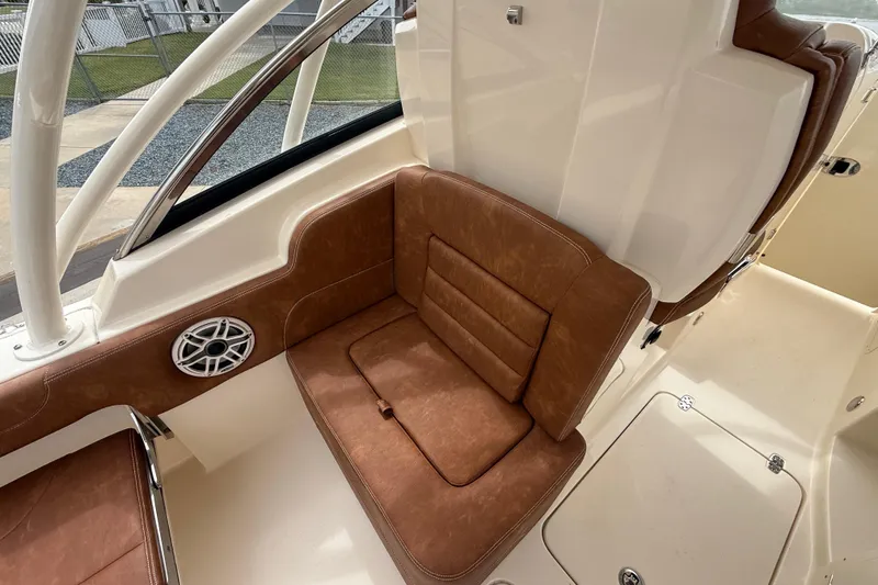 Slide: The Image of 2023 Scout 255 Dorado boat interior with brown leather seating and speaker. - 31