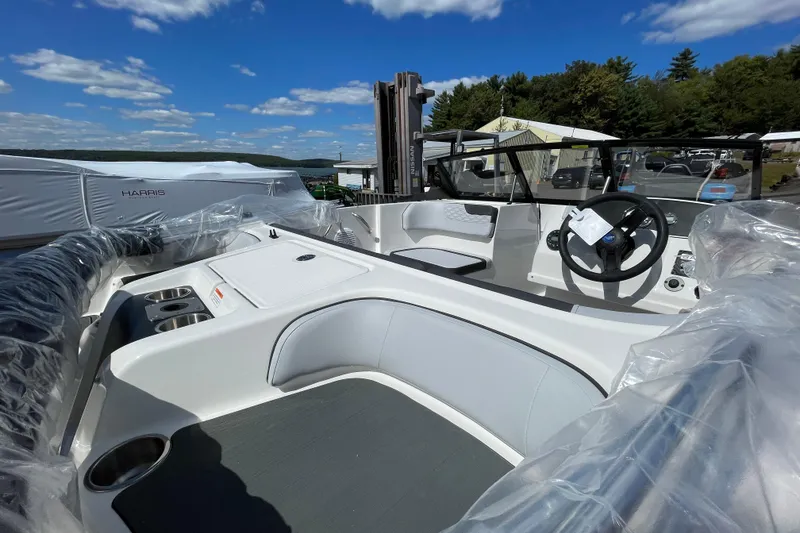 Slide: The Image of 2026 Bayliner Element E17 boat interior with seating and steering wheel under clear blue sky. - 7