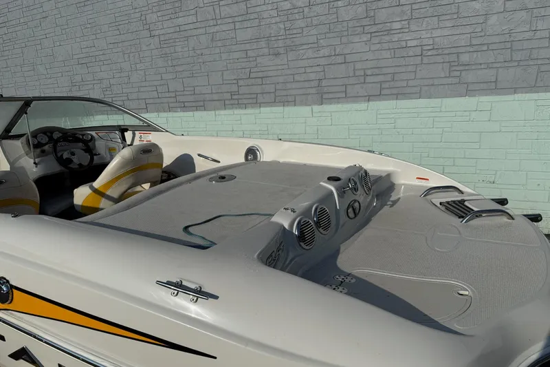 Slide: The Image of 2013 Tahoe Q5 boat interior with yellow-accented seats and dashboard, parked by a brick wall. - 4