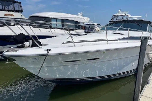 Slide: The Image of 1989 Sea Ray 390 Express Cruiser docked at marina, sleek white design. - 2