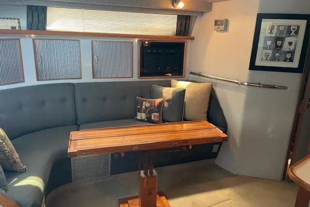 Slide: The Image of Interior of 1989 Sea Ray 390 Express Cruiser with cozy seating and wooden table. - 3