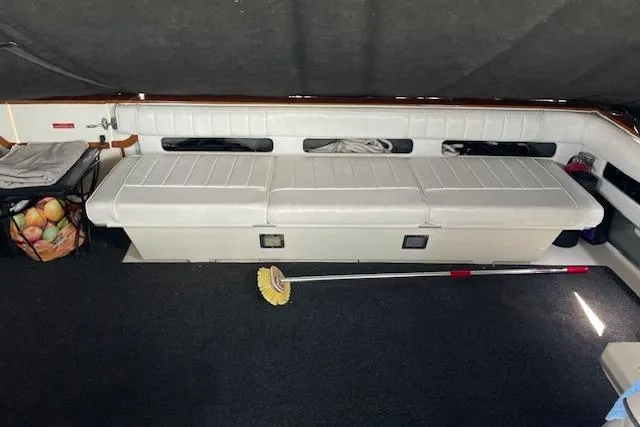 Slide: The Image of 1989 Sea Ray 390 Express Cruiser interior with seating and cleaning brush. - 5