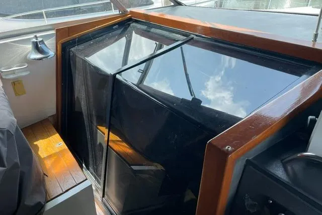 Slide: The Image of 1989 Sea Ray 390 Express Cruiser cabin entrance with wooden trim and glass panels. - 7