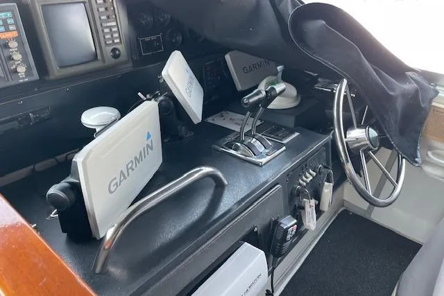 Slide: The Image of 1989 Sea Ray 390 Express Cruiser helm with Garmin navigation equipment and steering wheel. - 9