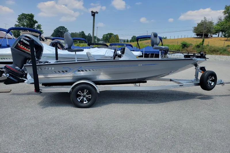 Slide: The Image of 2026 Xpress H18 Bass boat on trailer, parked outdoors under a clear sky. - 3